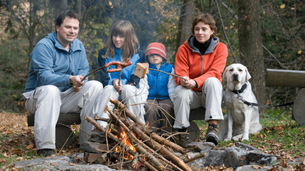 Family with a dog outside a pet-friendly Hapey Cabin rental minutes from downtown Gatlinburg