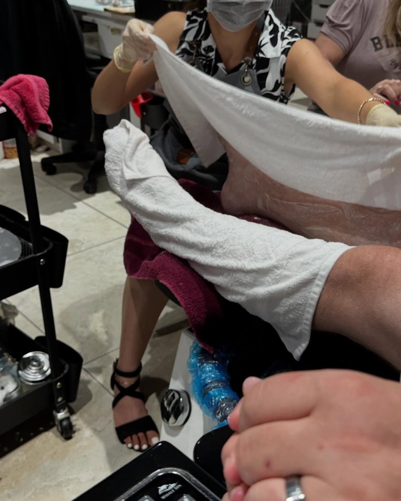 Feet being wrapped during the Deluxe Pedicure service offered at Noire Nail Bar in Sevierville, TN.