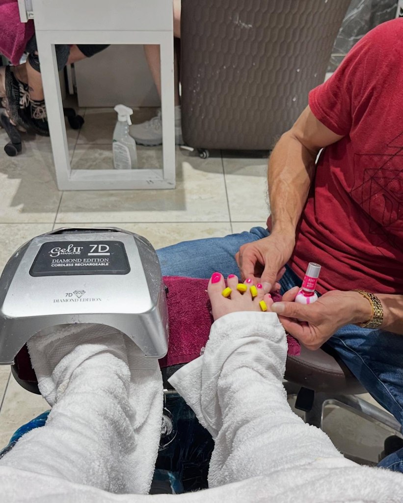 Female Patron receiving a gel coat pedicure and having the gel coating dried.