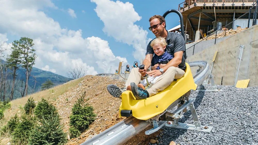 Father and son riding Anakeesta's Rail-Runner mountain coaster in gatlinburg tn via website