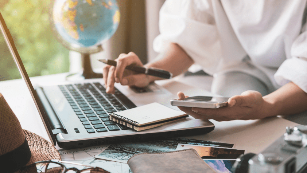 woman planning vacation with computer and cell phone