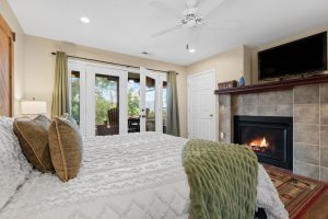 View of fireplace and bed from soaking tub sunny view cabin