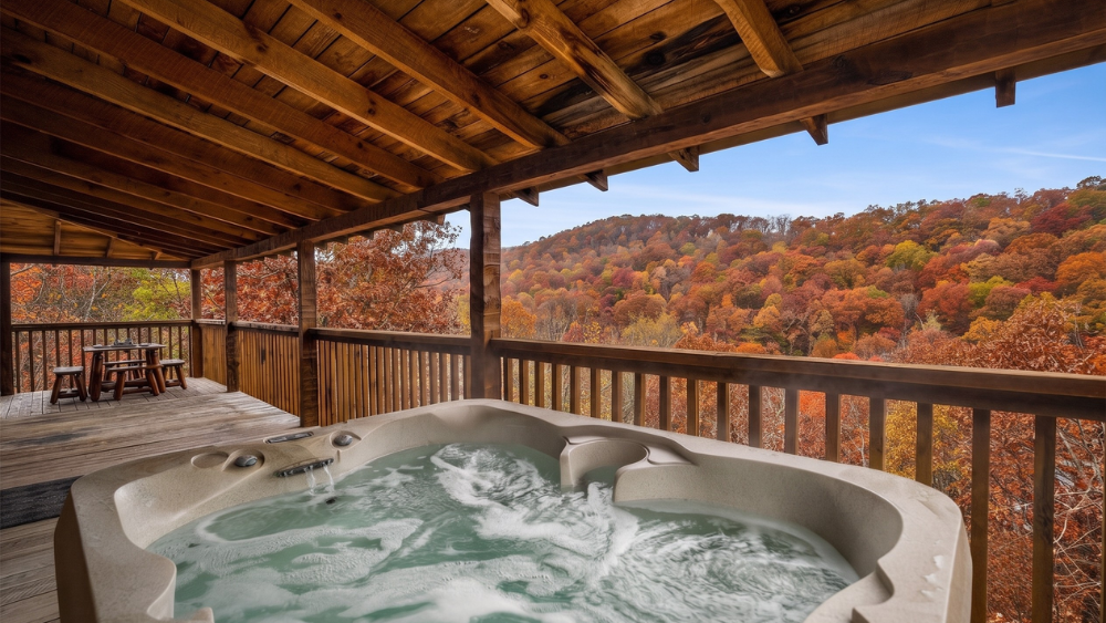 A relaxing hot tub on a cabin deck overlooking a beautiful Smoky Mountain view with autumn colors.
