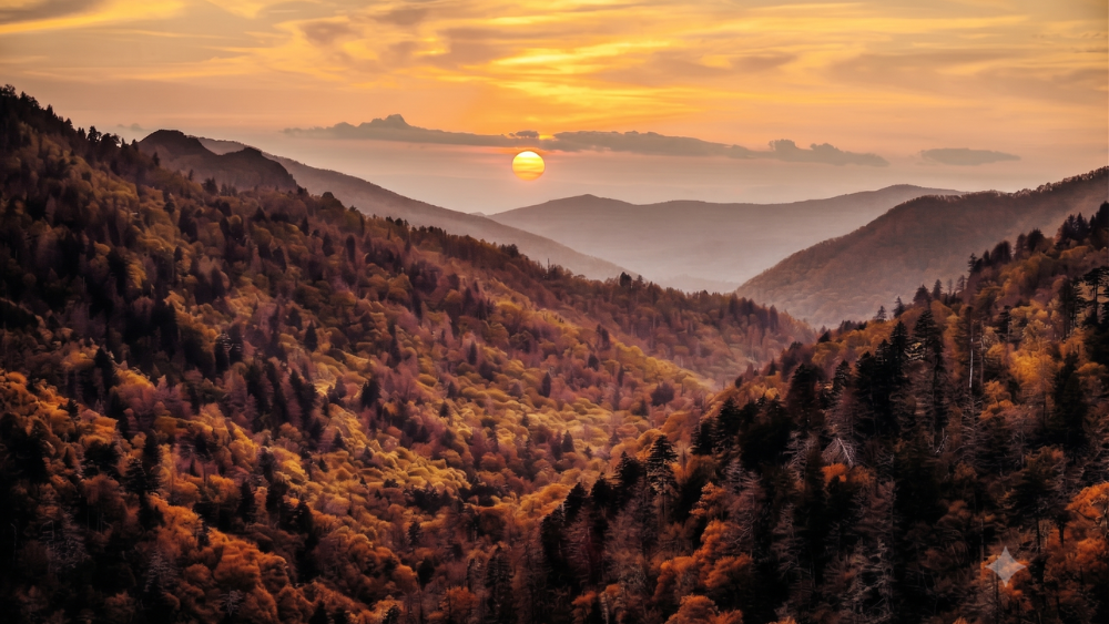 Panoramic view of layered blue mountain ridges and colorful fall foliage from Morton Overlook on Newfound Gap Road.
