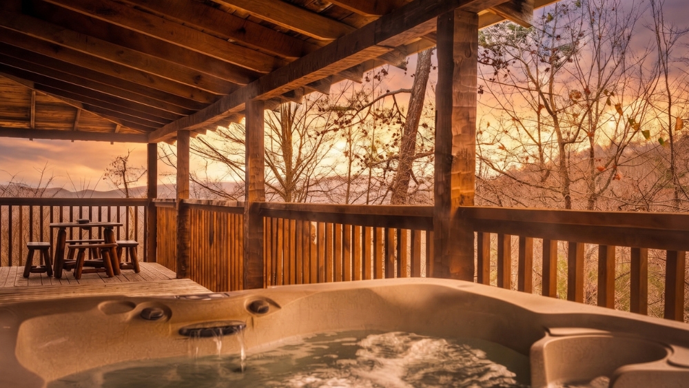 Private hot tub on a Hapey Cabin Rentals porch overlooking the Smoky Mountains at sunset