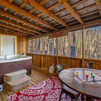 View of covered back porch and hot tub at Hapey Memories
