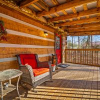 View of covered porch, front door and rocker at Hapey Memories