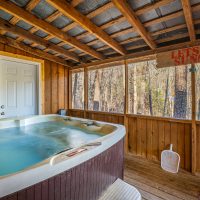 View of hot tub on covered back porch at Hapey Memories