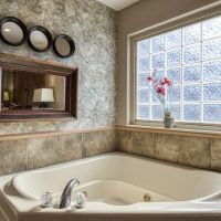 In-bedroom jacuzzi soaking tub with large natural light window at Sunny View Cabin Sevierville Tennessee romantic cabin rental